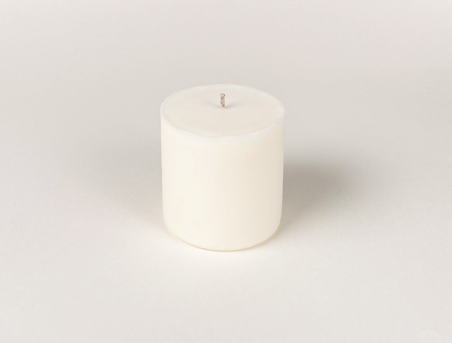 Photograph of a white Mylah Skye candle refill on an off white background