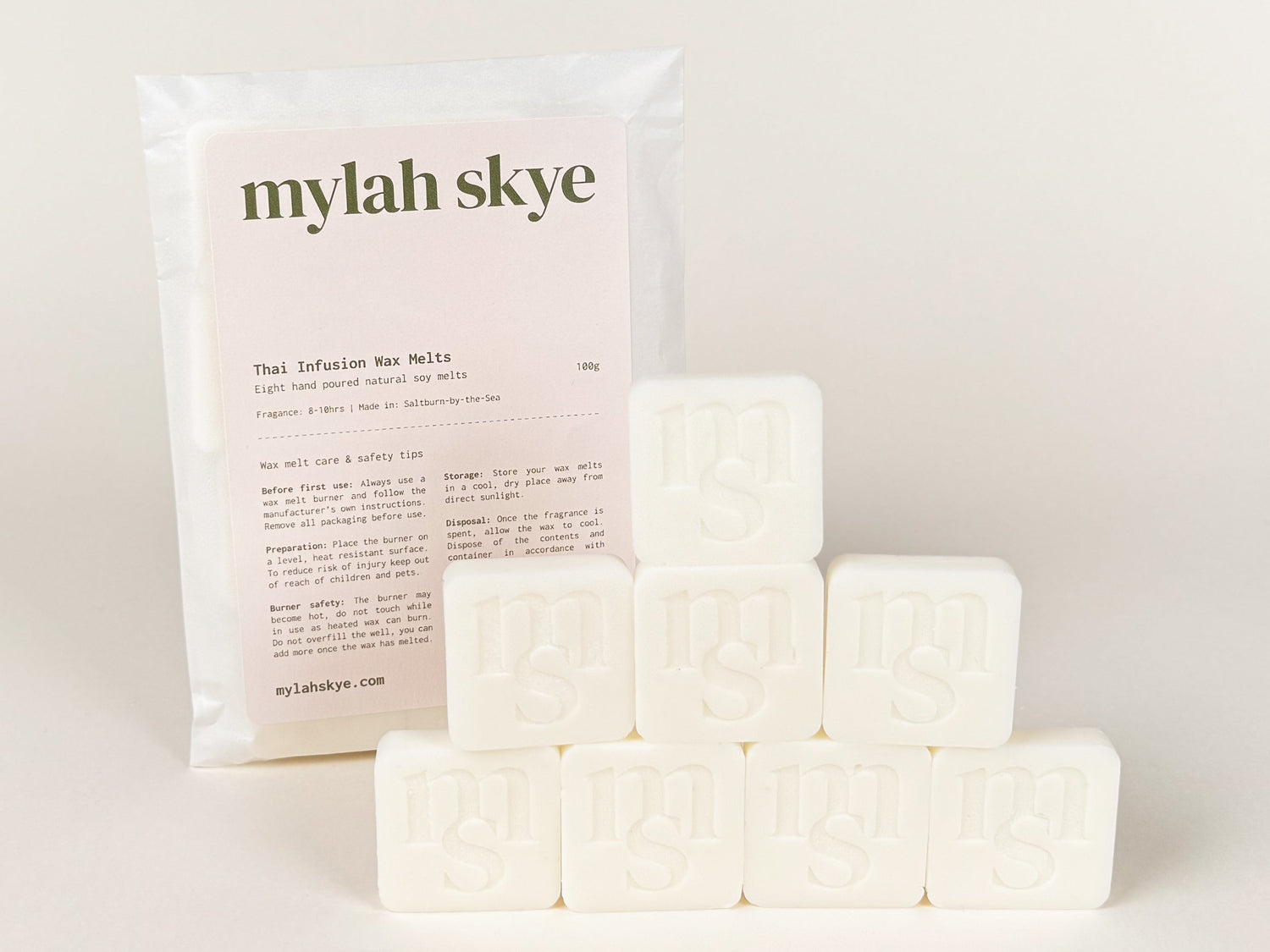 Photograph of eight wax melts against an off white background